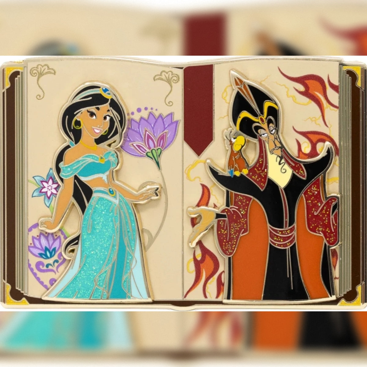 Detailed front view of the Pink a la Mode LE 300 pin (uncarded) Aladdin open storybook enamel pin, showing raised pin-on-pin figures of Jasmine in glitter teal and Jafar with Iago against flame details