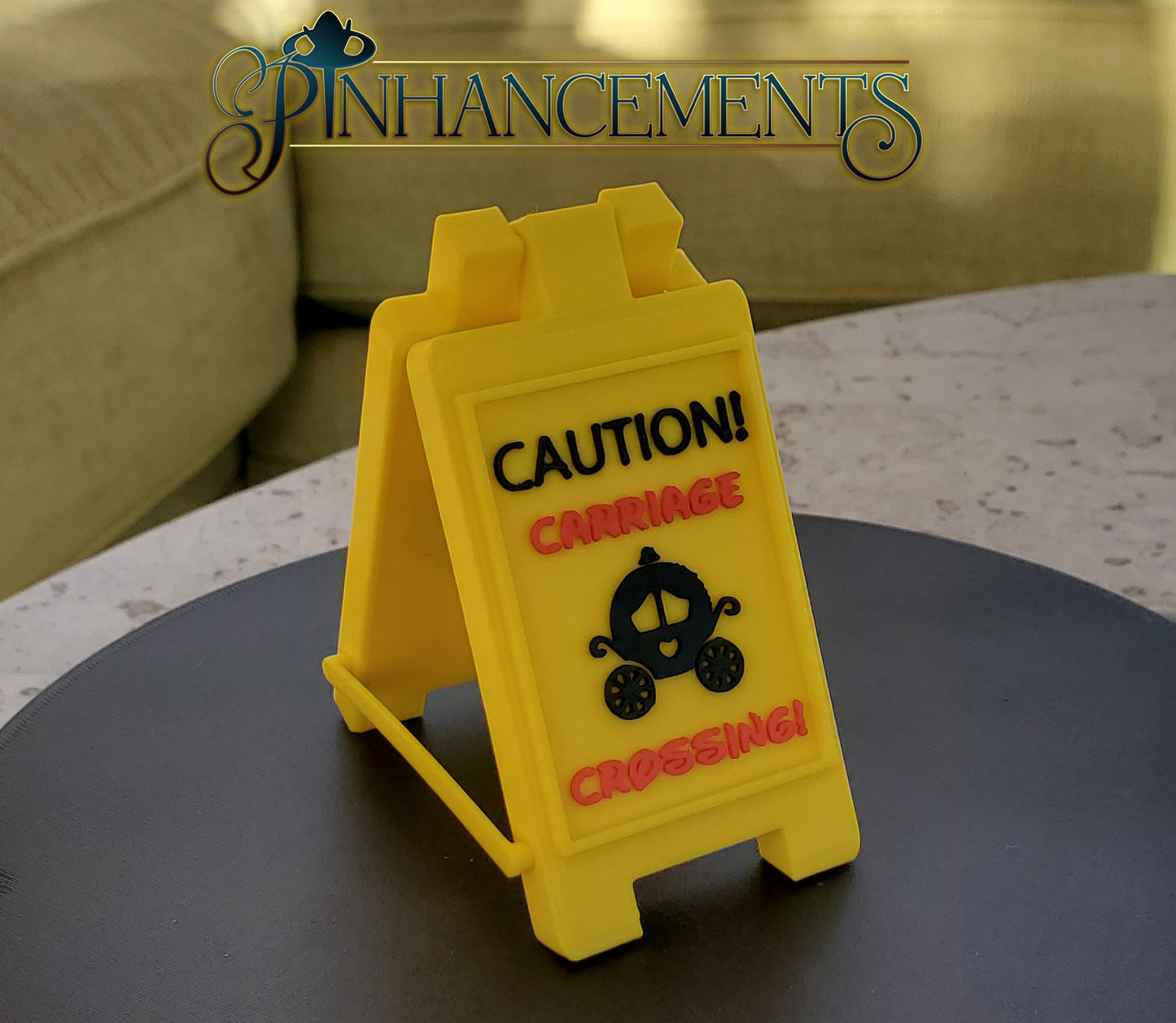 Yellow caution sign Carriage crossing with Cinderella carriage icon, branded 'Pinhancements'.