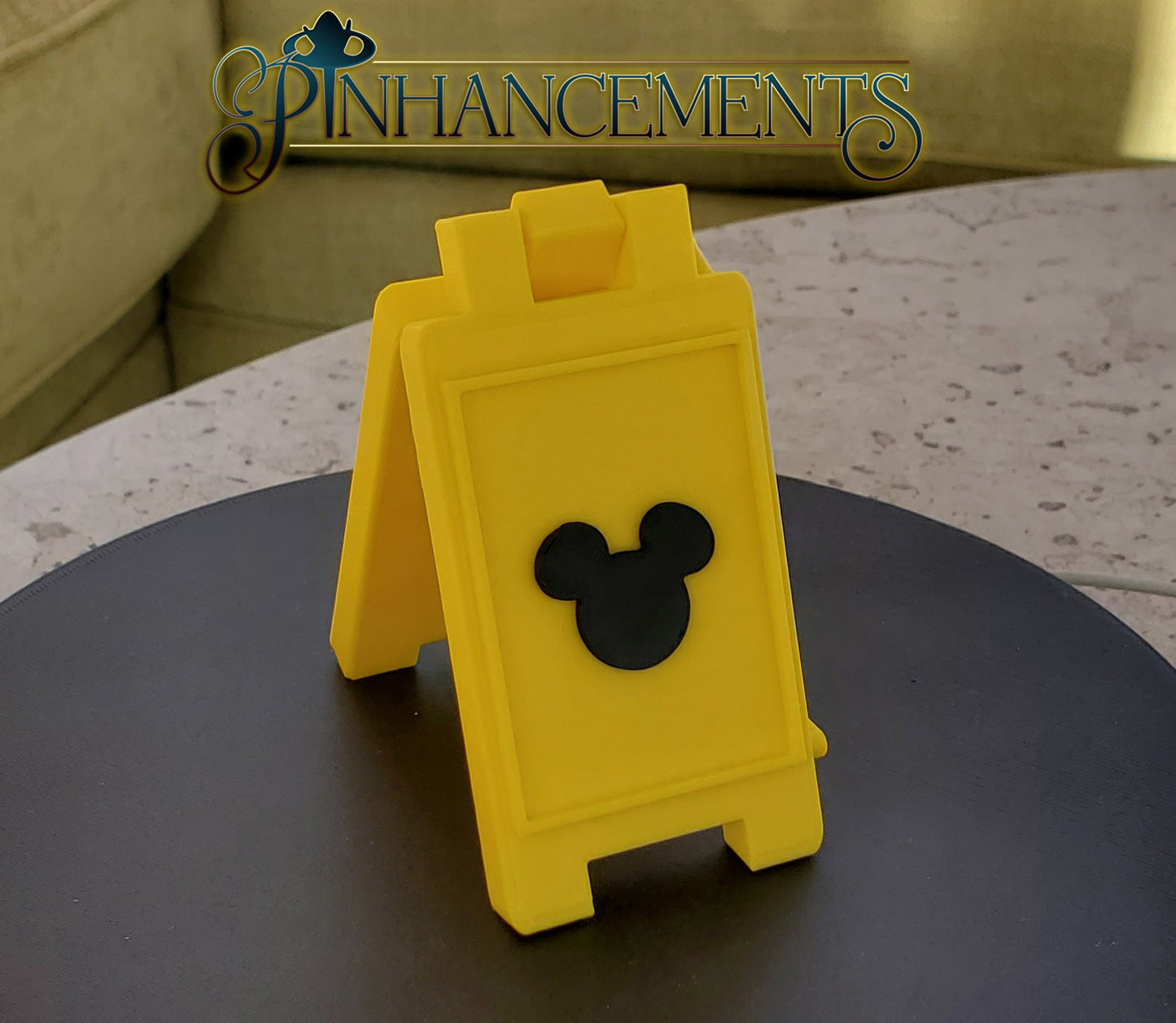 Yellow caution sign with Mickey Mouse silhouette, branded 'Pinhancements'.