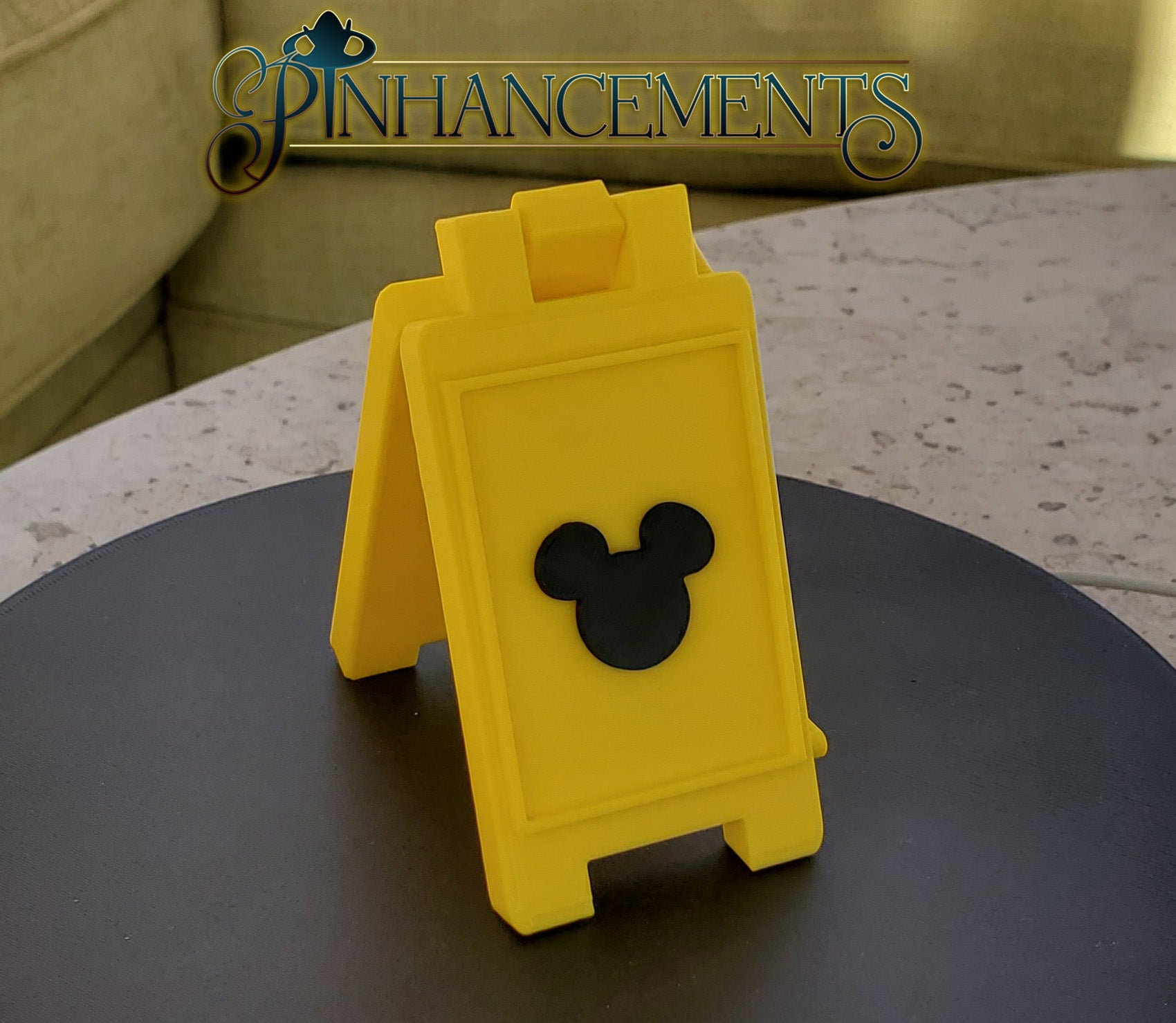 Yellow caution sign with Mickey Mouse silhouette, branded 'Pinhancements'.