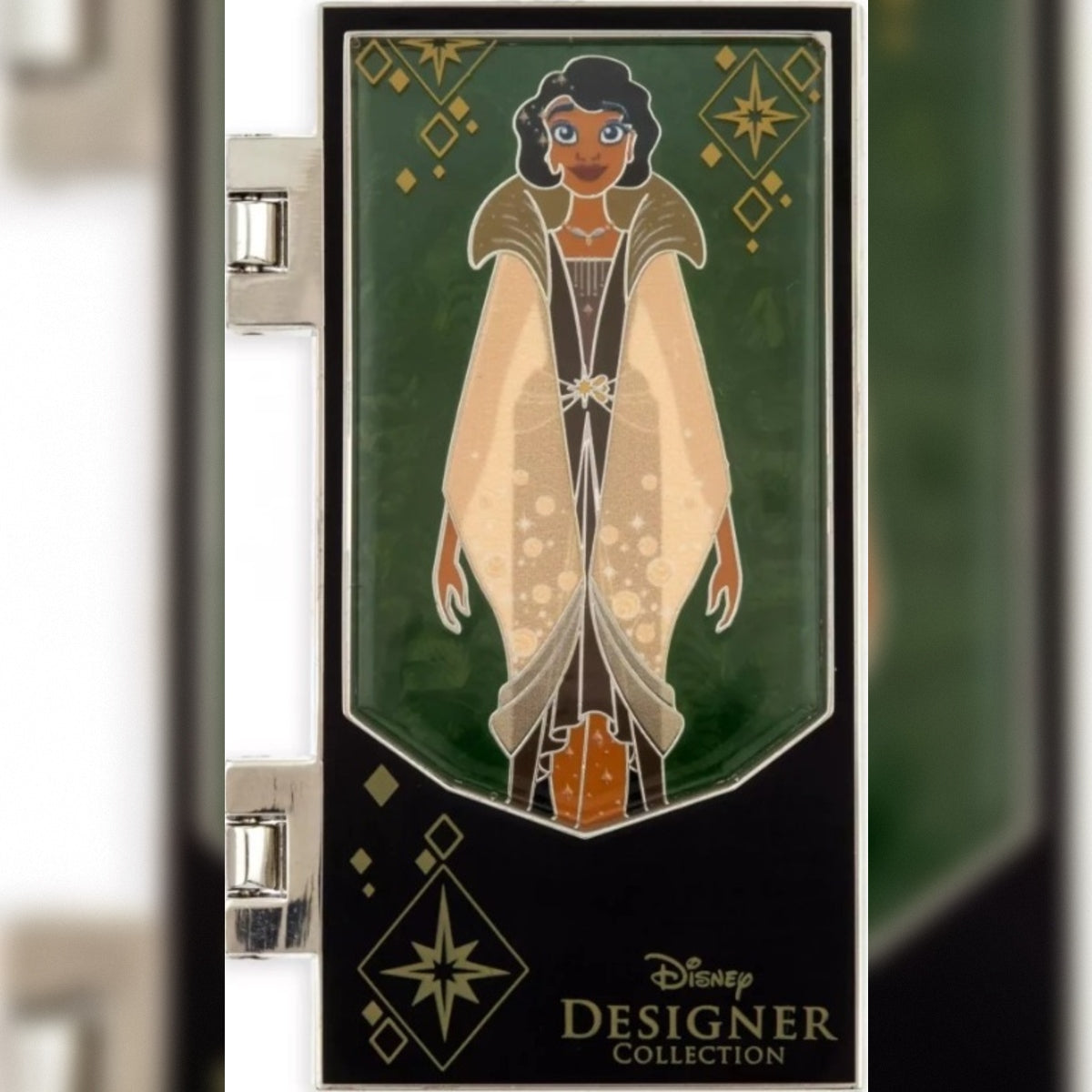 A Disney Designer Collection enamel pin featuring an Art Deco style illustration of Tiana in a beige cloak against a dark green and black background.