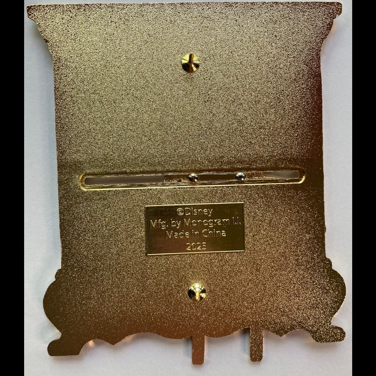 Belle Library Back of Pin showing Sliding mechanism, two posts, Disney Stamp, Monogram Manufacture stamp, and year stamp (2025)