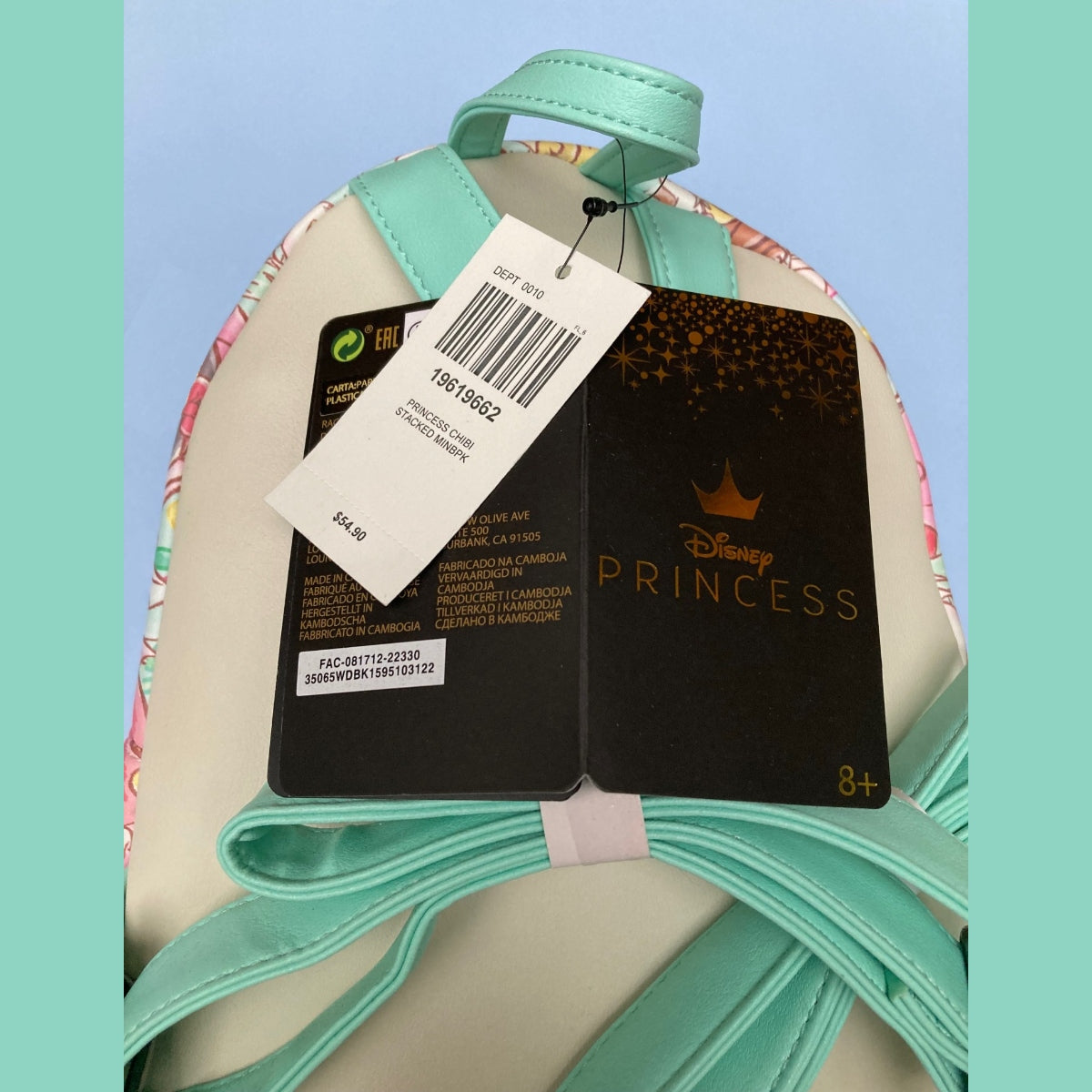 Close-up of the back of a Chibi AOP Disney Loungefly mini backpack with Teal straps and top handle, and two retail tags attached, including a Loungefly Disney Princess tag.