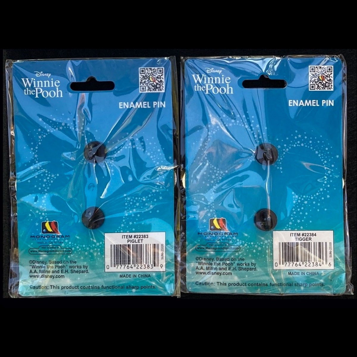 Backs of packaged Piglet and Tigger pins showing blue Disney Winnie the Pooh cards, rubber clutches and item labels.